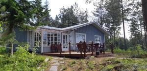 a tiny house in the woods with a deck at Mäntyniemi in Petäjävesi +10 photos