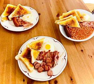 three plates of breakfast food on a wooden table at Top Twenty Bed and Breakfast in Windsor +2 photos