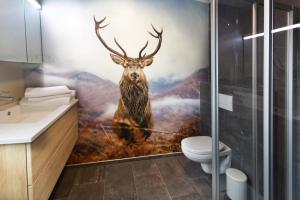 un baño con una pintura de un ciervo en la pared en Villa Mama - Luxus und Lebensfreude, en Seefeld in Tirol