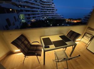 Habitación con balcón con mesa y sillas. en APARTAMENTO EN BENALBEACH en Benalmádena