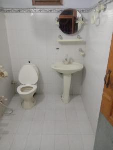 een witte badkamer met een toilet en een wastafel bij Akbar International View Hotel in Muzaffarabad