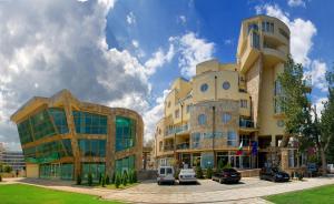 a group of buildings with cars parked in front of them at Viva Apartments in Sunny Beach