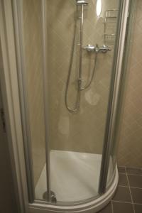 una ducha con puerta de cristal en un baño en Apartments Livia, en Jūrmala 68 fotos más