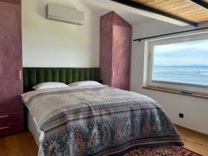 a bedroom with a large bed with a large window at Villa The View in Koper
