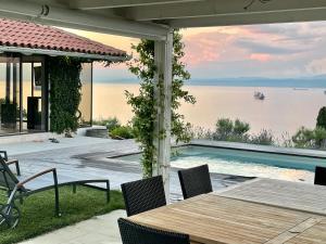 a patio with a table and chairs and a swimming pool at Villa The View in Koper