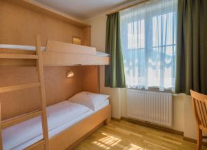 a bedroom with a bunk bed and a window at JUFA Hotel Altaussee in Altaussee +41 photos