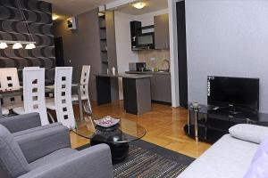 a living room with a couch and a tv and a kitchen at Lux apartment A38, Kraljevi čardaci, Kopaonik in Kopaonik