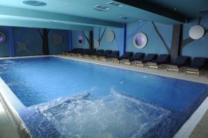 a large swimming pool with chairs in a room at Lux apartment A38, Kraljevi čardaci, Kopaonik in Kopaonik +9 photos