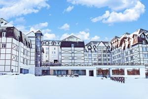 a large building with snow in front of it at Lux apartment A38, Kraljevi čardaci, Kopaonik in Kopaonik
