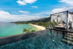 a swimming pool with a view of a beach at The Shore At Katathani - Adult Only - SHA Extra Plus in Kata Beach