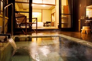 a swimming pool with a fountain in the middle of a room at Hakone Kowakien Mikawaya Ryokan in Hakone