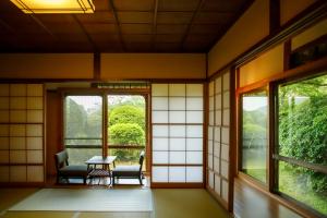 a room with windows and a table and chairs at Hakone Kowakien Mikawaya Ryokan in Hakone