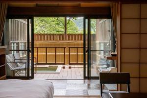 una camera con letto e un balcone con patio di Hakone Kowakien Mikawaya Ryokan a Hakone