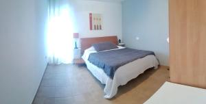 1 dormitorio con 1 cama en una habitación blanca en Casa do Horreo, en Puentecesures