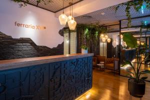 a bar in a restaurant with plants on the wall at Ferraria XVI FLH Hotels Lisboa in Lisbon