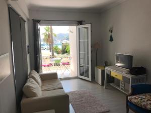 a living room with a couch and a television at Göcekinn in Göcek