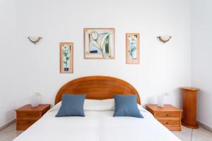 sypialnia z łóżkiem z dwoma stolikami nocnymi i 3 zdjęciami na ścianie w obiekcie Casa Naranja - Heated Pool - BBQ - Terrace - Free Wifi - Child & Pet-Friendly - 3 bedrooms - 6 people w mieście Poris de Abona