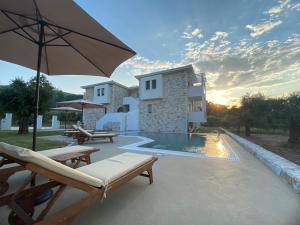 a villa with a swimming pool and a house at Luminous Luxury Apartments in Limenas