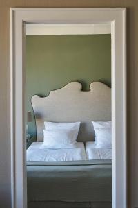 - un lit avec une tête de lit ainsi que des draps et des oreillers blancs dans l'établissement Hotel Monopol - Central Station, à Francfort-sur-le-Main