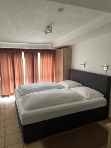 ein Schlafzimmer mit einem großen Bett mit weißer Bettwäsche in der Unterkunft Hotel Restaurant Germania in Neuwied