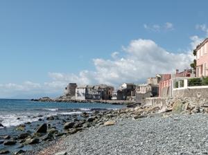 a rocky beach with houses and the ocean at Casa Luciani in Erbalunga