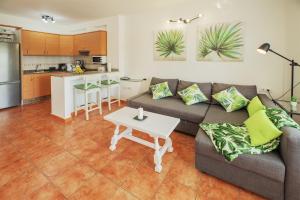 a living room with a couch and a table and a kitchen at Lanzahost Cucharas Dreams in Costa Teguise