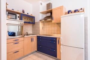a kitchen with blue cabinets and a white refrigerator at Apartment Blue Lagoon in Split