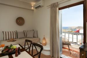 a living room with a couch and a balcony at Africanis Suites in Schinoussa