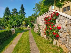 eine Steinmauer mit roten Blumen darauf in der Unterkunft Residence Ruje in Prepotto