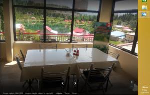 einen weißen Tisch und Stühle in einem Zimmer mit einem großen Fenster in der Unterkunft Shalimar Hotel And Restaurant in Ponedas