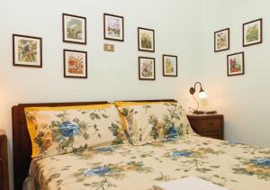 sypialnia z łóżkiem i oprawionymi obrazami na ścianie w obiekcie Il Sorgituro - Agriturismo w mieście Postiglione