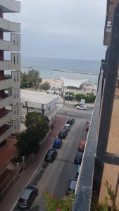 a street with cars parked in a parking lot next to the beach at Sweet Carola in Bari +25 photos