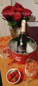una bottiglia di champagne e fragole su un tavolo con bicchieri da vino di Chalet with hot tub room a Clanfield