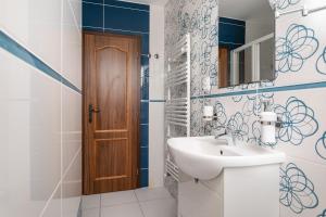 Łazienka z umywalką i drewnianymi drzwiami w obiekcie Penzion Závada w mieście Závada