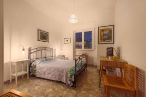 a bedroom with a bed and a table and a desk at RobertONE Guest House in Bari