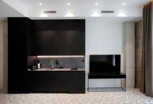 uma cozinha com um lavatório e uma televisão de ecrã plano em Fetén em Valência