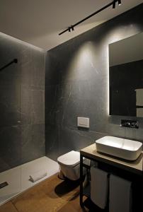 uma casa de banho com um WC, um lavatório e um espelho. em Fetén em Valência