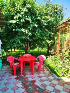 einen roten Tisch und zwei rote Stühle um einen Tisch. in der Unterkunft Guest House Dinara in Kaji-Say