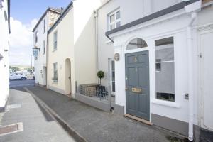 a white building with a blue door on a street at 1 Quayside in Appledore