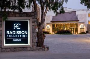 a sign in front of a building with a raisson collection at Radisson Collection Hotel, Bodrum in Akyarlar