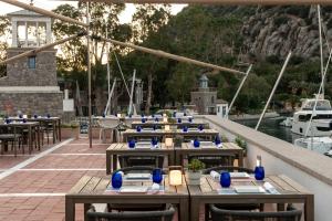 a row of tables and chairs on a dock with boats at Radisson Collection Hotel, Bodrum in Akyarlar