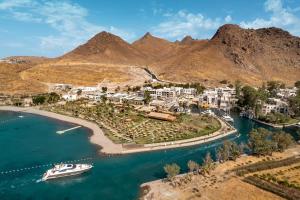 an island in the water with a boat in it at Radisson Collection Hotel, Bodrum in Akyarlar