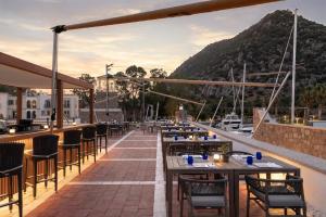 a restaurant with tables and chairs and a mountain at Radisson Collection Hotel, Bodrum in Akyarlar