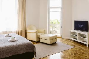 um quarto com uma cama, uma cadeira e uma televisão em Hangers em Turda