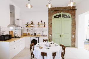 a kitchen with a table and a green door at Hangers in Turda
