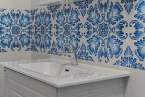a bathroom with a sink and blue and white tiles at Stabiaeflor Apartment in Castellammare di Stabia
