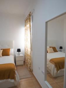uno specchio in una camera con due letti di Apartamento Horizonte El Puertito de Güímar a Puertito de Güímar