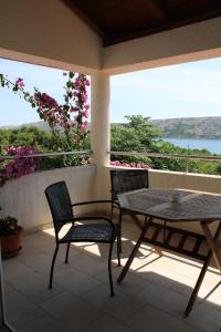 un patio con 2 sedie e un tavolo sul balcone di Apartments Maria Rab a Barbat na Rabu