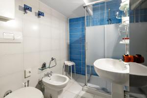La salle de bains est pourvue d'un lavabo, de toilettes et d'une douche. dans l'établissement Hotel Britannia, à Gênes