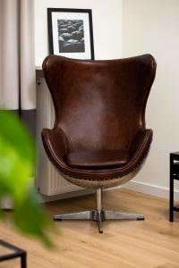 a brown leather chair sitting in a living room at Apartments Warsaw Gagarina by Renters in Warsaw